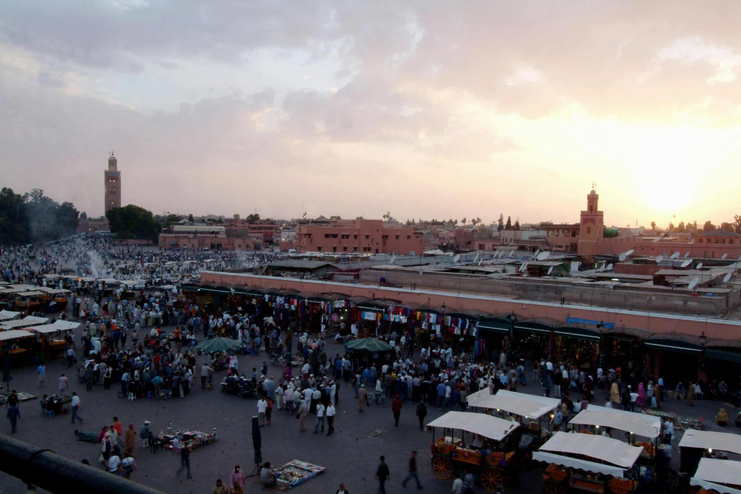 Bustling Jemaa el-Fnaa in Marrakech at sunset, showcasing a lively market scene.