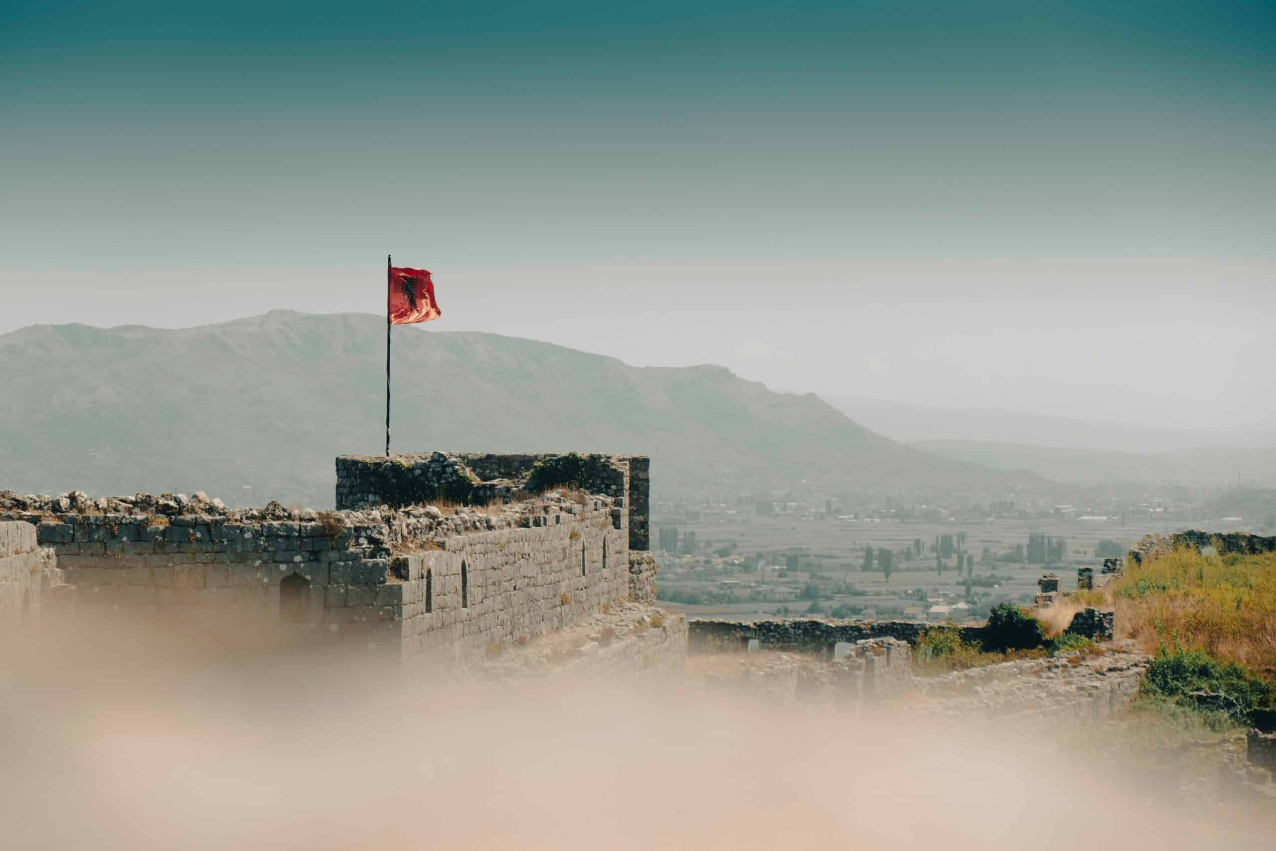 Scenic view of Rozafa Castle with the Albanian flag waving in Shkodër, Albania.