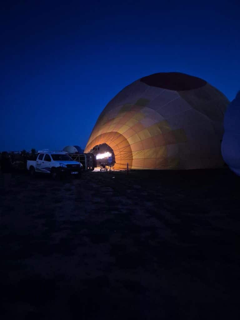 Imagen del globo al amanecer llenándose de aire caliente en Capadocia
