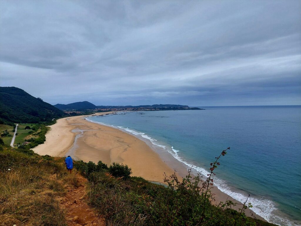 Imagen de la playa de Helgueras en cuanto pasas el montecillo. Delante mio una peregrina. Al fondo Noja